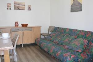 ein Wohnzimmer mit einem Sofa und einem Tisch in der Unterkunft Ronce-les-Bains - APPARTEMENT REZ-DE-CHAUSSEE gauche - 90m de la PLAGE in Ronce-les-Bains