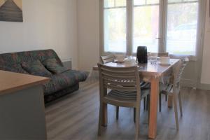 ein Wohnzimmer mit einem Tisch, Stühlen und einem Sofa in der Unterkunft Ronce-les-Bains - APPARTEMENT REZ-DE-CHAUSSEE gauche - 90m de la PLAGE in Ronce-les-Bains