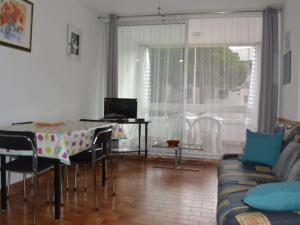 ein Wohnzimmer mit einem Tisch und einem Sofa in der Unterkunft Appartement Le Grau-du-Roi, 2 pièces, 4 personnes - FR-1-250-136 in Le Grau-du-Roi