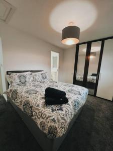 Un dormitorio con una cama con una bolsa negra. en Stunning 3-Bed House in Oldbury en Birmingham