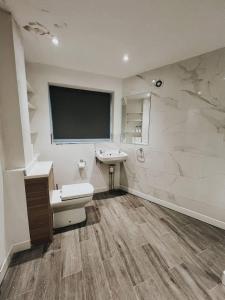 a bathroom with a toilet and a sink and a tv at Stunning 3-Bed House in Oldbury in Birmingham