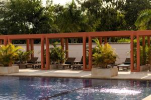 a pool with tables and chairs next to a fence at Hotel Morúa in Yopal