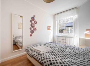 Habitación blanca con cama y espejo en One-bed flat Payment required STRAIGHT away the host will message you after you've made a reservation, en Londres