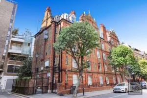 a red brick building with a tree in front of it at One-bed flat Payment required STRAIGHT away the host will message you after you've made a reservation in London