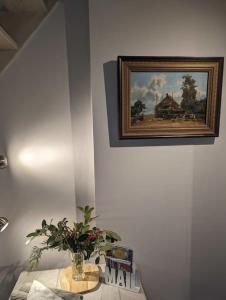 a painting of a house on a wall with a plant at Het Pakhuis Haarlem in Haarlem