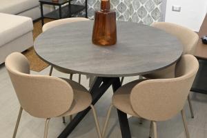 een tafel met stoelen en een vaas erop bij Casa karas in Milaan
