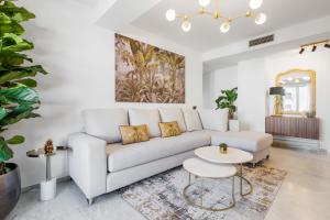 uma sala de estar com um sofá branco e uma mesa em Tennessee Penthouse em Málaga