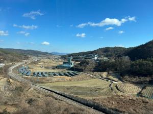 an aerial view of a farm with a train tracks at Top Motel in Suncheon