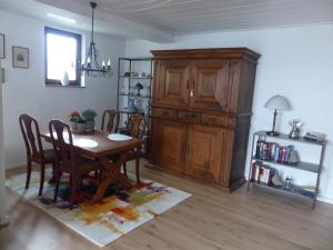 a dining room with a table and a wooden cabinet at Ruhiges Ferienhaus im Garten in Bad Salzuflen