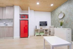 eine Küche mit einem roten Kühlschrank und einem Tisch in der Unterkunft Apartamento en la mejor zona de Triana, junto al puente in Sevilla