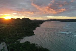 uma vista aérea do oceano ao pôr-do-sol em Miley Lodging Restobar em New Busuanga