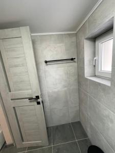 een badkamer met een douche, een deur en een raam bij OneDay in Verkhovyna