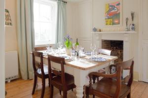 un comedor con una mesa con copas de vino en The Villa in Coberley - Stylish 3BD with Garden!, 