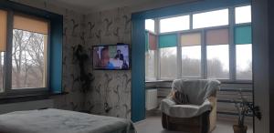 una camera da letto con sedia e TV a parete di ONE BEDROOM APARTMENT in IF city :) a Ivano-Frankivsʼk
