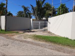 a white fence with a gate on the side of a road at Chacara Oliva in Piracicaba