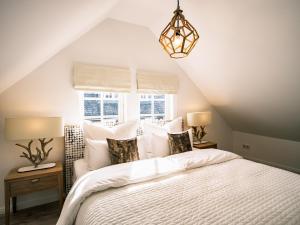 een slaapkamer met een bed met witte lakens en een raam bij Flecker Hotel in Freudenberg
