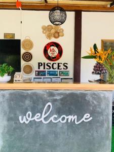 a chalk board with a welcome sign on a counter at Pisces Tourist Inn - Port Barton in San Vicente