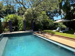 a swimming pool with a deck and an umbrella at Green Elephant in Lilongwe