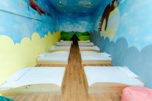 a row of beds in a room with a mural at Tykes Inn - Childcare and Day Hotel Exclusively for Kids in Colombo