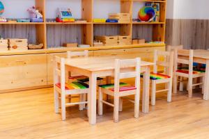 a wooden table and chairs in a room at Tykes Inn - Childcare and Day Hotel Exclusively for Kids in Colombo