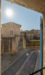 Aussicht aus einem Fenster eines alten Gebäudes und einer Straße in der Unterkunft Maison tout confort, climatisée, dans le Centre Historique avec parking privé. in Saint-Rémy-de-Provence