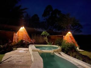 a swimming pool in a backyard at night at Triangular house and hot spring in Kubupenlokan