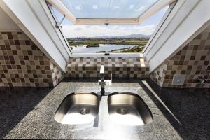a bathroom with a sink with a large window at Dolphin Beach H301 by Host Agents in Bloubergstrand +24 photos
