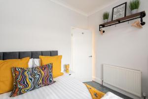a bedroom with a bed with yellow pillows at Belgrave in Darlington