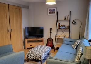 un salon avec deux canapés bleus et une télévision dans l'établissement 3 Bedroom Townhouse, Free Parking, à York