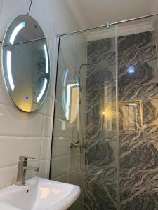 a bathroom with a shower and a sink and a mirror at Elegant 3 Bedroom Apartment in Lekki