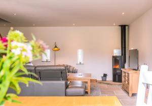 a living room with a couch and a tv at Union Farm Cottage in Reeth