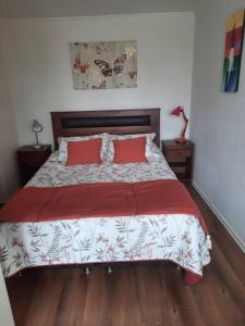 1 dormitorio con 1 cama grande con almohadas rojas en Depto con Estacionamiento, en Puerto Montt