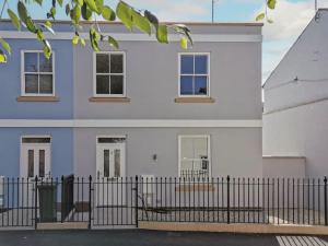 uma casa branca com uma cerca à frente. em Stunning 2 Bed with Private Patio and Free Parking em Cheltenham