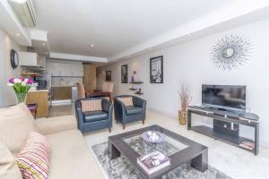 ケープタウンにあるWaterfront Canal - Fully Equipped One Bedroom Apartmentのソファとテーブルのあるリビングルーム