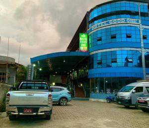 um edifício azul com carros estacionados em frente em Hotel Good One em Pokhara