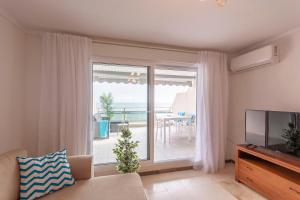 Telewizja i/lub zestaw kina domowego w obiekcie Apartamento Frentemar 1 by Costa CarpeDiem
