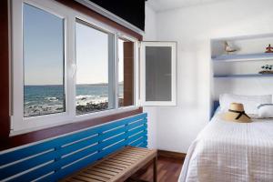 1 dormitorio con 1 cama y 2 ventanas con vistas al océano en El Mar y Tú, en Arrieta