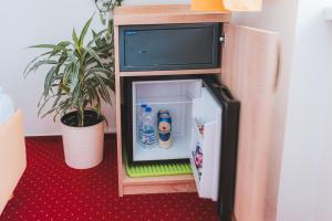 un piccolo frigorifero con bottiglie d'acqua all'interno di Kavárna a penzion REICHL a Králíky
