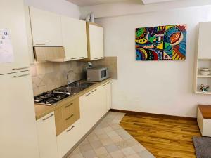 eine Küche mit weißen Schränken und einer Spüle und einer Mikrowelle in der Unterkunft Ca' De Mezo near San Marco in Venedig + 14 Fotos