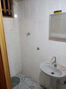 a white bathroom with a sink and a shower at Recanto Averomar in Itanhaém