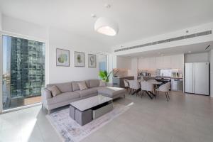 a living room with a couch and a table and a kitchen at 3Bed Private Beach - Belle vie à La Vie Dubai in Dubai