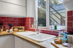 a kitchen with a sink and a window at Coastal View Cottage in Torquay