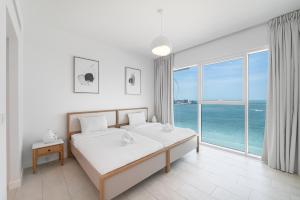 a bedroom with a bed with a view of the ocean at 3Bed Private Beach - Belle vie à La Vie Dubai in Dubai