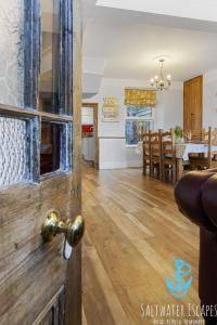 a door to a dining room and living room with a table at Coastal View Cottage in Torquay