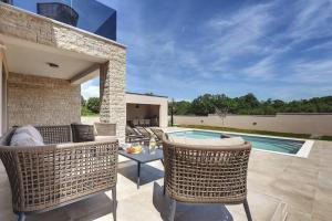a patio with two chairs and a swimming pool at Villa Omnia by Istrialux in Loborika