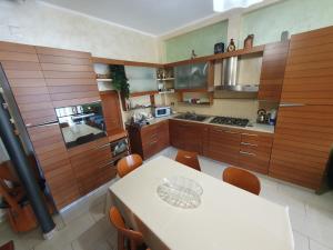 a kitchen with wooden cabinets and a table with chairs at Appartamento Andromeda con 3 camere da letto, Parcheggio privato e 2 Bagni in Potenza