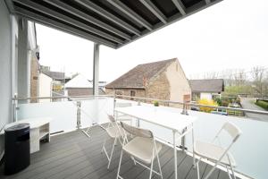 un balcone con tavoli e sedie bianchi sul tetto di DWK: Monteurhaus Braubach bei Koblenz a Braubach