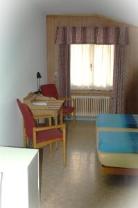 um quarto com uma mesa e cadeiras, uma mesa e uma cama em Seehotel Bären em Brienz
