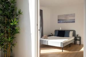 ein Schlafzimmer mit einem Bett und einer Pflanze in der Unterkunft CENTRIC APARTMENT CAMP NOU 2 in Hospitalet de Llobregat