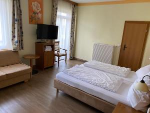 1 dormitorio con 1 cama, TV y sofá en Marienhof en Bad Tölz